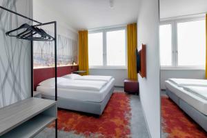 a hotel room with two beds and a television at Campanile Berlin Brandenburg Airport in Schönefeld