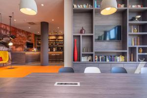 a dining room with a table and chairs and a tv at Campanile Berlin Brandenburg Airport in Schönefeld