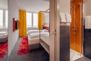a hotel room with two beds and a shower at Campanile Berlin Brandenburg Airport in Schönefeld