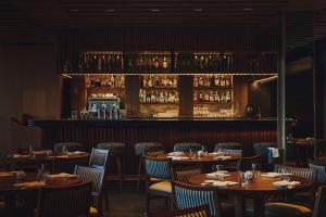 a restaurant with tables and chairs and a bar at Nobu Hotel San Sebastián in Donostia-San Sebastián