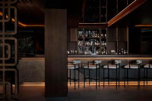 a bar with four stools in front of a counter at Nobu Hotel San Sebastián in Donostia-San Sebastián