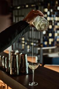 a person pouring money into a wine glass at Nobu Hotel San Sebastián in Donostia-San Sebastián
