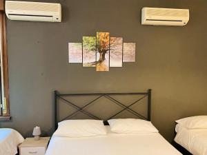 a bedroom with a bed and three paintings on the wall at B&B Viale Manzoni in Sassuolo