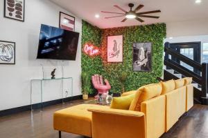 a living room with a yellow couch and a green wall at Carrollton Beautiful House with Pool in Carrollton