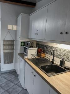 eine Küche mit weißen Schränken und einem Waschbecken in der Unterkunft Estúdio em Alte - KARMEA HOUSES in Alte