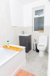 Baño blanco con aseo y lavamanos en 4 bedroom Bungalow, en Slades Green