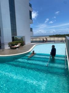 une femme et un enfant dans une piscine dans l'établissement Flat a beira mar, à Récife