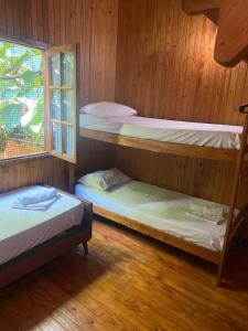 three bunk beds in a room with a window at El Pindo Iguazu in Puerto Iguazú