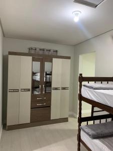 - une chambre avec 2 lits superposés et une commode avec des miroirs dans l'établissement Pousada vale do paraíso, à Navegantes