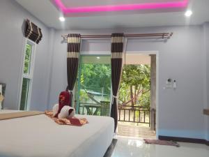 a bedroom with a bed and a balcony at Pana Long Beach Resort - SHA Plus in Ko Lanta