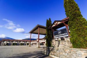 um sinal em frente a um hotel com um edifício em Northwinds Hotel Revelstoke em Revelstoke