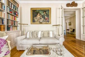 a living room with a white couch and a painting at Gros Caillou - Grenelle 2bdr in Paris
