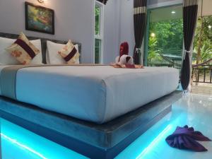 a bedroom with a large bed and a swimming pool at Pana Long Beach Resort - SHA Plus in Ko Lanta