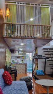 a living room with a couch and a staircase at Daet Transient Tiny House staycation 2-6px in Daet