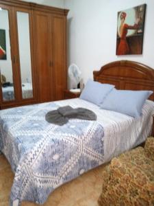 a bedroom with a bed with a blue and white blanket at Habitaciónes Privadas Cartagena Murcia in Cartagena