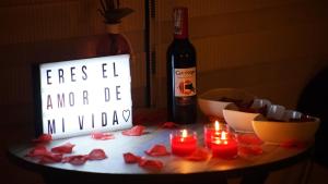 una mesa con velas y una botella de vino en PISCINA SARITA CLUB BOUTIQUE en Girardot