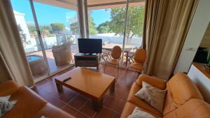 a living room with a couch and a tv and a table at CASA COSTA VOLCAN in Teguise