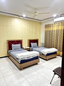 1 dormitorio con 2 camas y techo en The Crown en Islamabad