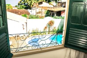 ein offenes Fenster mit Blick auf einen Balkon in der Unterkunft Pousada dos Quatro Cantos in Olinda