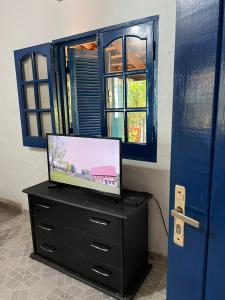 telewizor siedzący na komodzie obok okna w obiekcie Granja Relax w mieście Itauguá