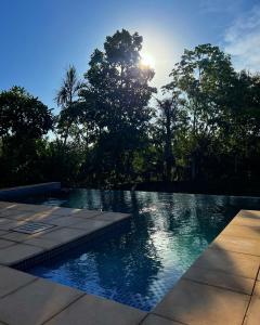 a swimming pool with the sun in the background at Granja Relax in Itauguá