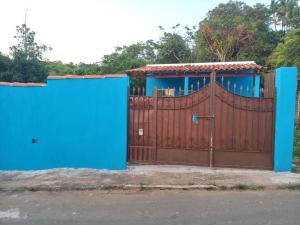 a blue fence with a brown and blue gate at Casa Azul in Passos
