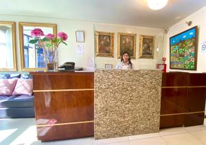 a woman standing behind a counter in a room at Arequipa Inn in Arequipa