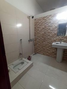 a bathroom with a shower with a sink and a tub at The Crown in Islamabad