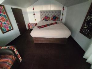 Un dormitorio con una cama grande con almohadas. en TITICACA WORLDWIDE LODGE en Puno