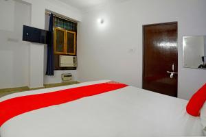 a bedroom with a large white bed with a red blanket at OYO Flagship Hotel Drip Inn in Hasanganj