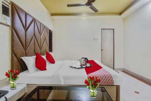 una camera da letto con un letto con cuscini rossi di Hotel Derby a Ulhāsnagar