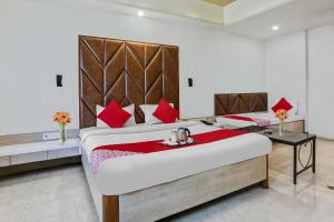 una camera da letto con un grande letto con cuscini rossi di Hotel Derby a Ulhāsnagar
