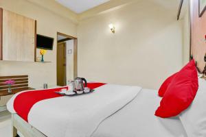 Camera con letto e cuscini rossi di Hotel Derby a Ulhāsnagar