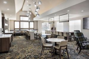 uma sala de jantar com mesas, cadeiras e janelas em Residence Inn by Marriott Corona Riverside em Corona