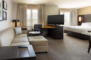 a hotel room with a couch and a bed at Residence Inn by Marriott Corona Riverside in Corona