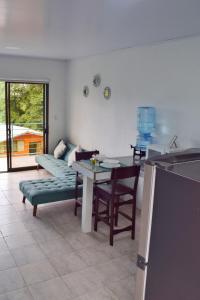 een woonkamer met een tafel en een bank bij Ocean's Breeze Apartment and Rooms in Puerto Viejo