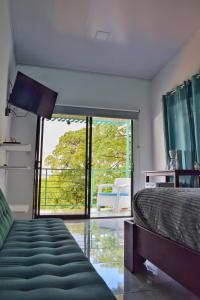 a bedroom with a bed and a large window at Ocean's Breeze Apartment and Rooms in Puerto Viejo