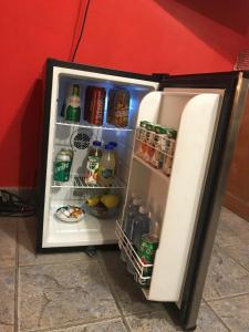 un frigorifero a pianta aperta con bevande e bevande di Habitación privada Barrio Uno a Ezeiza