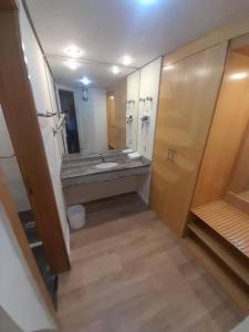 a bathroom with a sink and a large mirror at Sol Alphaville Flat Equipado lazer e trabalho in Barueri