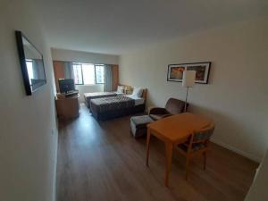 a living room with a bed and a table at Sol Alphaville Flat Equipado lazer e trabalho in Barueri +11 photos