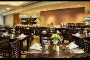 a restaurant with tables and chairs and a bar at Sol Alphaville Flat Equipado lazer e trabalho in Barueri