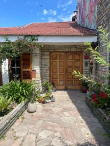 una casa con una puerta de madera y algunas plantas en Habitación privada Barrio Uno en Ezeiza