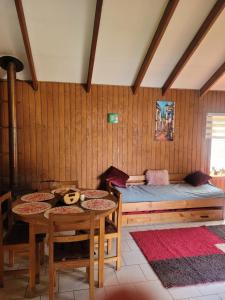 a room with a bed and a table and chairs at Cabañas Arévalo in Futrono