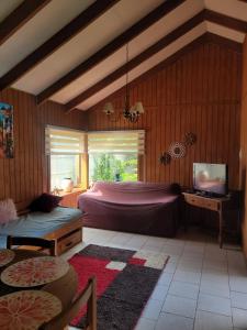 a bedroom with a bed and a tv in it at Cabañas Arévalo in Futrono