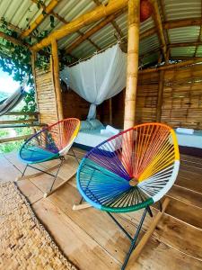 twee stoelen op een terras met een bed bij El Cielo Biohospedaje in Tena