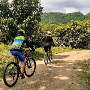two people riding bikes down a dirt road at El Cielo Biohospedaje - Reserva Natural Sostenible in Tena