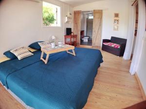 a bedroom with a blue bed and a table at L'Auxilliadora - Studio cozy en bord de mer in Sainte-Anne