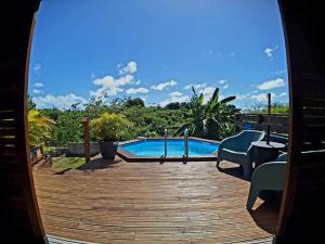 a view of a swimming pool from a wooden deck at L'Auxilliadora Studio - Bord de Mer et Piscine in Sainte-Anne