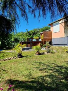 een tuin met een huis en wat planten bij L'Auxilliadora - Studio cozy en bord de mer in Sainte-Anne