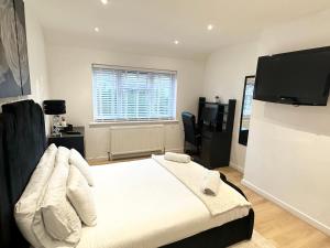 a bedroom with a bed and a flat screen tv at Charming 3-Bed Home Minutes From City Centre in Nottingham